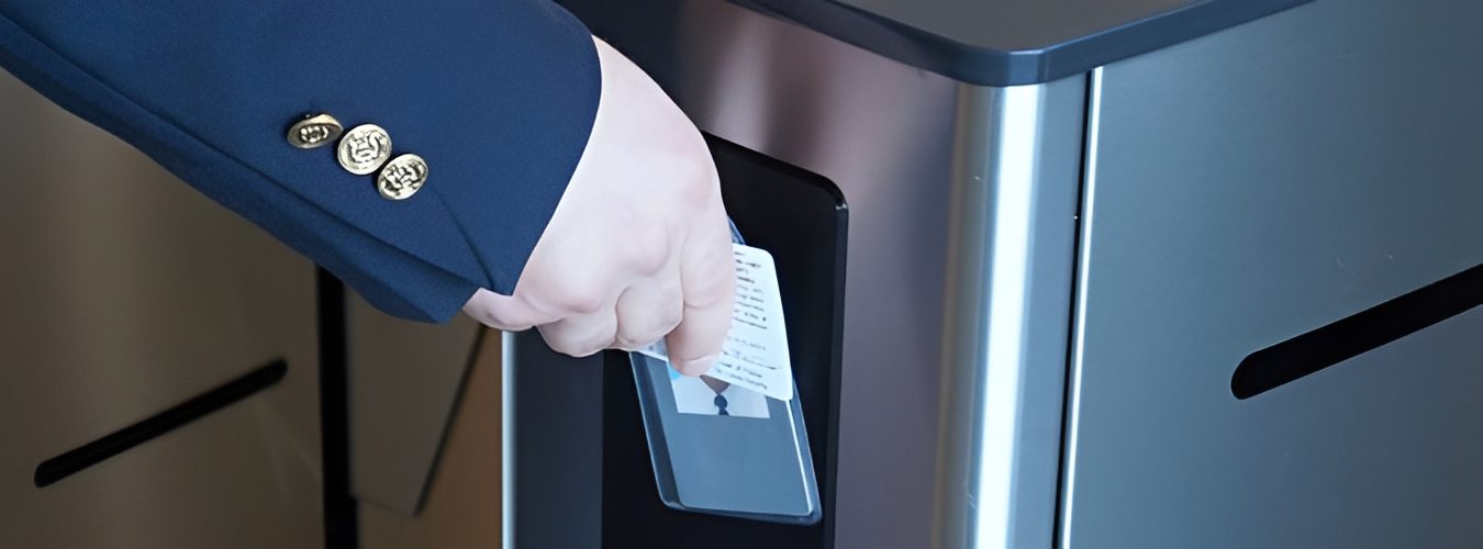 Person in a suit holding a card in their hand, inserting it into a voting machine